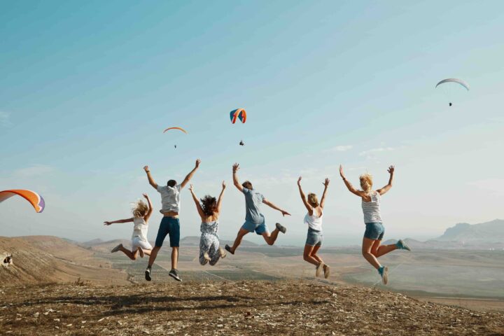 group-friends-jumping-top-hill